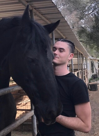 Landon Recht posing with a horse.